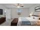 A staged main bedroom with neutral carpet, white walls, large window and a door to the bathroom at 3186 Oyster Cove St, Wimauma, FL 33598