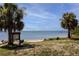 Picturesque beach featuring palm trees and serene water views for a tranquil coastal experience at 350 Kentucky Ave, Crystal Beach, FL 34681