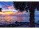 Scenic beach view showcasing vibrant sunset colors reflecting on the water with palm trees at 350 Kentucky Ave, Crystal Beach, FL 34681