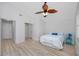 Bright bedroom featuring light wood floors, ceiling fan, and coastal decor at 350 Kentucky Ave, Crystal Beach, FL 34681