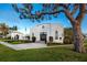 Elegant white building with a charming architectural design, complemented by manicured landscaping and a nearby palm tree at 350 Kentucky Ave, Crystal Beach, FL 34681