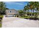 Beautiful home featuring a spacious driveway, lush lawn, and mature palm trees, creating a welcoming and serene atmosphere at 350 Kentucky Ave, Crystal Beach, FL 34681
