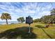 Scenic view of Gulf Shore Park with a historical marker, lush green grass, benches, and calm water in the background at 350 Kentucky Ave, Crystal Beach, FL 34681