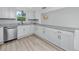 Well-lit kitchen features granite countertops, ample white cabinetry, and modern stainless steel appliances at 350 Kentucky Ave, Crystal Beach, FL 34681