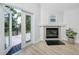 Bright living room featuring a fireplace and French doors leading to the outside deck at 350 Kentucky Ave, Crystal Beach, FL 34681