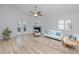 Living room with whitewashed decor, ceiling fan, and a cozy fireplace, complemented by neutral furniture at 350 Kentucky Ave, Crystal Beach, FL 34681