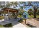 Charming park area with a gazebo, benches, and a little free library surrounded by lush greenery and trees at 350 Kentucky Ave, Crystal Beach, FL 34681