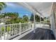 Exterior porch with white railings and a view of the green, tropical surrounding area at 350 Kentucky Ave, Crystal Beach, FL 34681