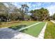 Well-maintained shuffleboard court in a park setting with mature trees offering shade and a relaxing atmosphere at 350 Kentucky Ave, Crystal Beach, FL 34681