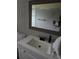 A bathroom featuring a white vanity with a dark faucet and framed mirror at 3614 E Grove St, Tampa, FL 33610