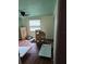 View of a bedroom featuring a ceiling fan, a window with blinds, and hardwood floors at 3614 E Grove St, Tampa, FL 33610