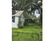 Exterior shot features white siding, chain-link fence, and lush greenery at 3614 E Grove St, Tampa, FL 33610