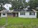 Charming home featuring white painted brick, modern solar panels, and a cozy front yard at 3614 E Grove St, Tampa, FL 33610