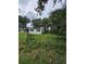 Exterior shot features white siding, a chain-link fence, and lush greenery at 3614 E Grove St, Tampa, FL 33610