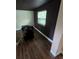 A room with dark laminate flooring and a small window with white blinds at 3614 E Grove St, Tampa, FL 33610