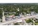 This aerial view shows the home nestled in a tree-filled area, near a busy commercial street and auto dealerships at 3632 E Comanche Ave, Tampa, FL 33610