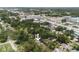 A high-angle shot shows the property surrounded by lush trees in a residential neighborhood near commercial zones at 3632 E Comanche Ave, Tampa, FL 33610