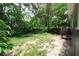 Backyard featuring lush trees and partial grass coverage, providing a tranquil outdoor space at 3632 E Comanche Ave, Tampa, FL 33610