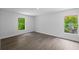 Bright bedroom with wood-look flooring and two windows at 3632 E Comanche Ave, Tampa, FL 33610