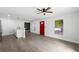 Bright, open-concept living room with modern gray flooring, a ceiling fan, and a view of the front yard at 3632 E Comanche Ave, Tampa, FL 33610