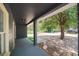 View of the covered porch with a tree providing shade in the front yard at 3632 E Comanche Ave, Tampa, FL 33610