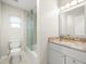 Bathroom featuring granite countertops, modern lighting, and tile shower at 4016 Windtree Dr, Tampa, FL 33624