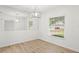 This dining room has a modern light fixture, large mirror, and a window overlooking the front yard at 4016 Windtree Dr, Tampa, FL 33624