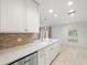 Bright kitchen featuring an island with white countertops and tile flooring at 4016 Windtree Dr, Tampa, FL 33624