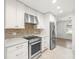 The updated kitchen features white cabinets and stainless steel appliances at 4016 Windtree Dr, Tampa, FL 33624