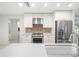 Modern kitchen boasts white cabinets, stainless steel appliances, and tile backsplash at 4016 Windtree Dr, Tampa, FL 33624