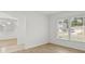 This living room features a window overlooking the front yard and hardwood floors at 4016 Windtree Dr, Tampa, FL 33624