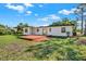 The backyard has a wood deck, lush grass, and mature trees at 4379 Porpoise Se Dr, St Petersburg, FL 33705