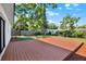 The backyard has a wood deck surrounded by grass and landscaping at 4379 Porpoise Se Dr, St Petersburg, FL 33705