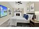 This bedroom features a stone fireplace, light hardwood floors, and a ceiling fan at 4379 Porpoise Se Dr, St Petersburg, FL 33705