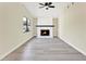 Spacious living room with a stone fireplace, wood mantle, ceiling fan, and hardwood floors at 4379 Porpoise Se Dr, St Petersburg, FL 33705