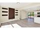 Open-concept living area featuring modern flooring, a statement wall, and sliding glass doors to the backyard at 4379 Porpoise Se Dr, St Petersburg, FL 33705