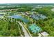 Aerial view featuring a lake, walking trails, a basketball court, and community amenities at 4383 Ortona Ln, Wesley Chapel, FL 33543