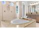 Luxurious bathroom featuring a soaking tub, walk-in shower, and granite countertops at 4383 Ortona Ln, Wesley Chapel, FL 33543