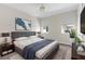 Comfortable bedroom featuring a gray bed, stylish lamps, and soothing wall art at 4383 Ortona Ln, Wesley Chapel, FL 33543