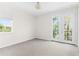 Bright bedroom featuring carpet floors, a window, and a private balcony at 4383 Ortona Ln, Wesley Chapel, FL 33543