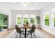Bright dining area with table and many windows showing lush greenery at 4383 Ortona Ln, Wesley Chapel, FL 33543
