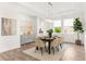 Elegant dining room with a modern chandelier, large windows, and a neutral color palette at 4383 Ortona Ln, Wesley Chapel, FL 33543