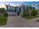 Beautiful blue two-story home featuring a 3-car garage and lush landscaping at 4383 Ortona Ln, Wesley Chapel, FL 33543