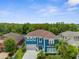 Beautiful two-story home featuring a blue exterior, well-manicured lawn, and mature landscaping at 4383 Ortona Ln, Wesley Chapel, FL 33543