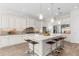 Gourmet kitchen features a large center island with seating, white cabinets, and stainless steel appliances at 4383 Ortona Ln, Wesley Chapel, FL 33543
