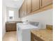 Spacious laundry room with granite countertops and ample cabinet storage space at 4383 Ortona Ln, Wesley Chapel, FL 33543