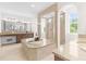 Luxurious main bathroom with a soaking tub, walk-in shower, and dual vanity at 4383 Ortona Ln, Wesley Chapel, FL 33543