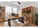 Bright office features a stylish desk, bookshelves, a plush chair, and ample natural light at 4383 Ortona Ln, Wesley Chapel, FL 33543
