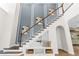 Beautiful staircase featuring decorative wall panels and integrated storage beneath, complemented by wood flooring at 4383 Ortona Ln, Wesley Chapel, FL 33543