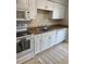 The kitchen includes sleek white cabinetry, a microwave, and an oven, and view of kitchen rug at 5155 9Th N Ave # 311, St Petersburg, FL 33710